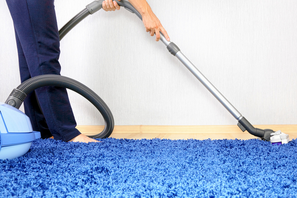 Vacuum cleaner in action-men cleaner a carpet.